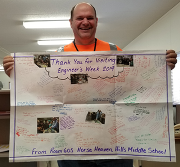 A Bechtel engineer displays the thank you note he received from students after volunteering during Discover E.
